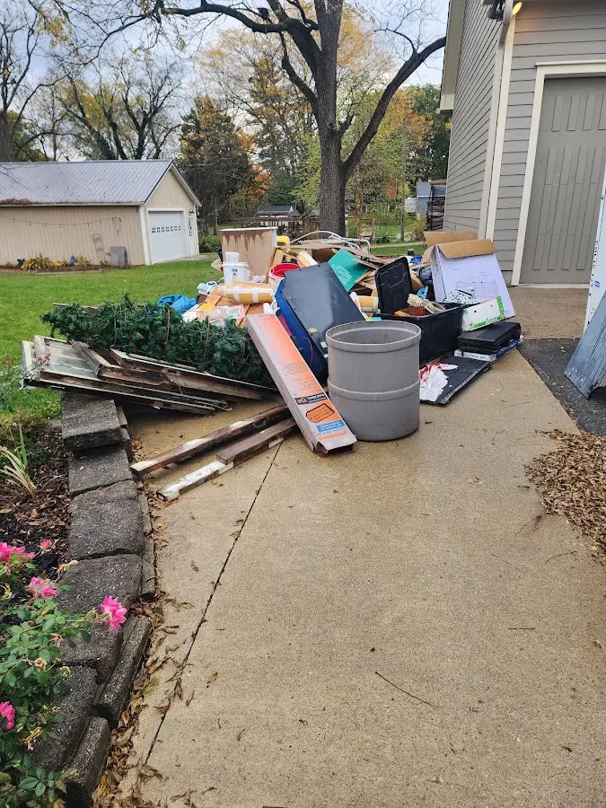Dumpster being loaded with debris for 12 Yard Dumpster Rental in Troy